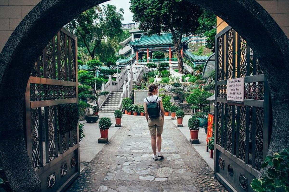 uma pessoa caminhando por um arco em um jardim