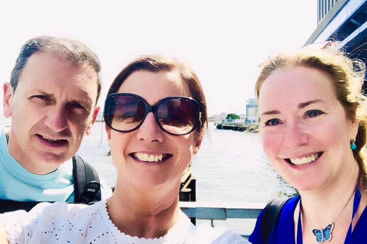 two women and a man posing for a picture on a boat