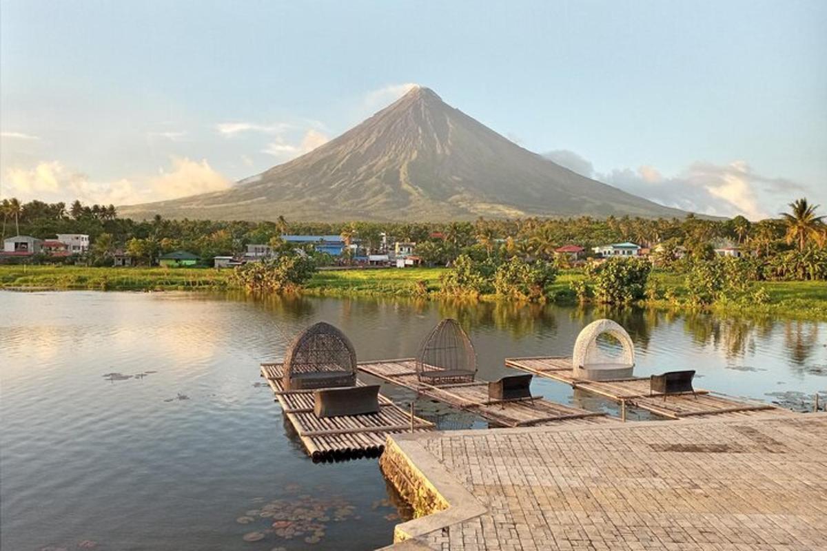 a mountain in the background with benches in the water