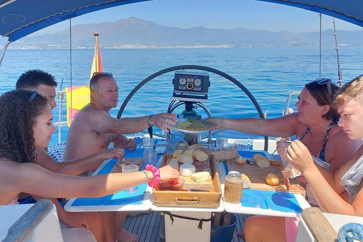 cilvēku grupa, kas sēž ap galdu uz laivas