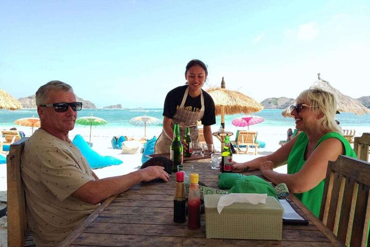 a group of people sitting at a table on the beach