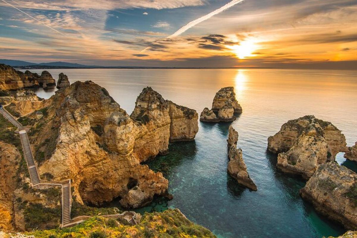 un tramonto sull'oceano con rocce nell'acqua