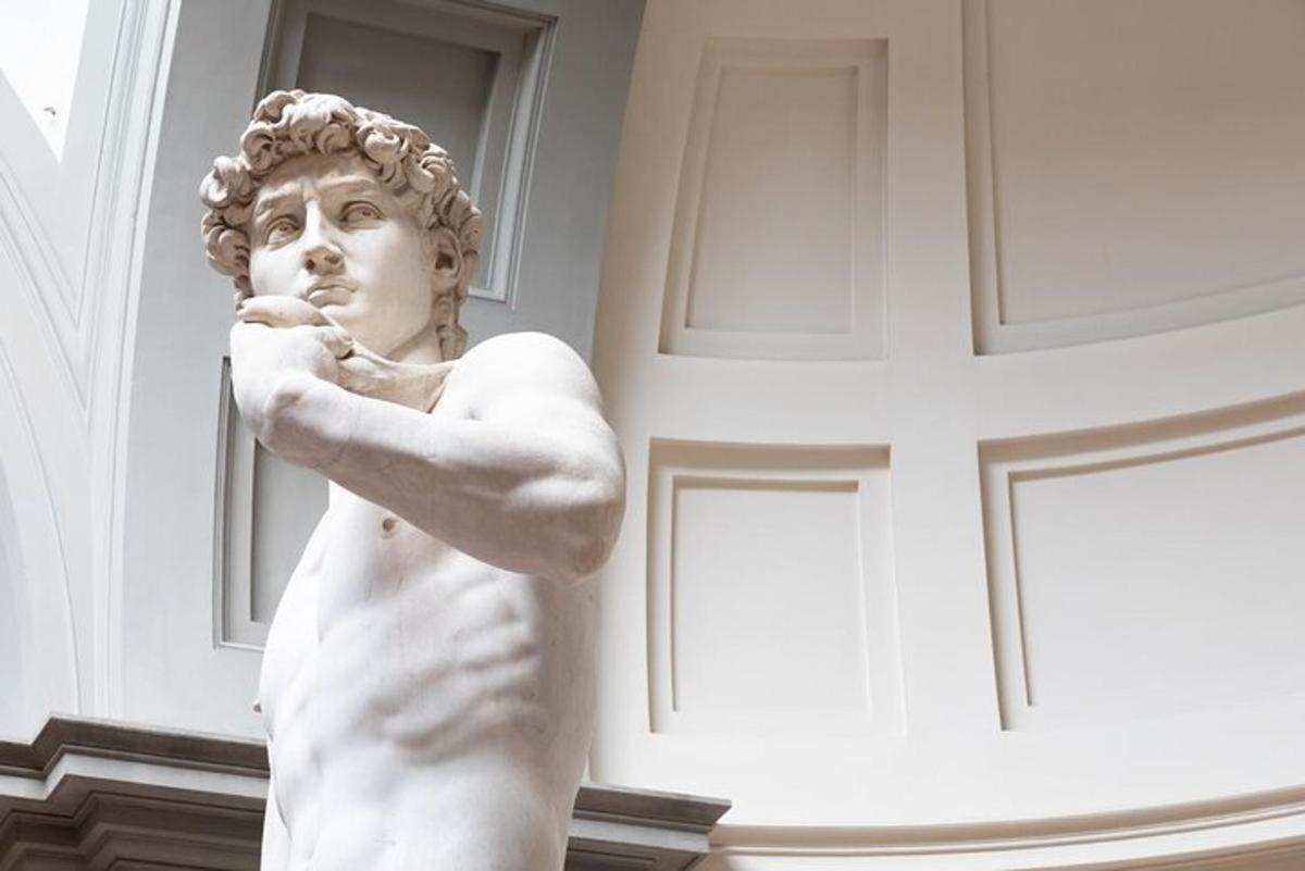 eine Statue eines Mannes, der vor einer Wand steht