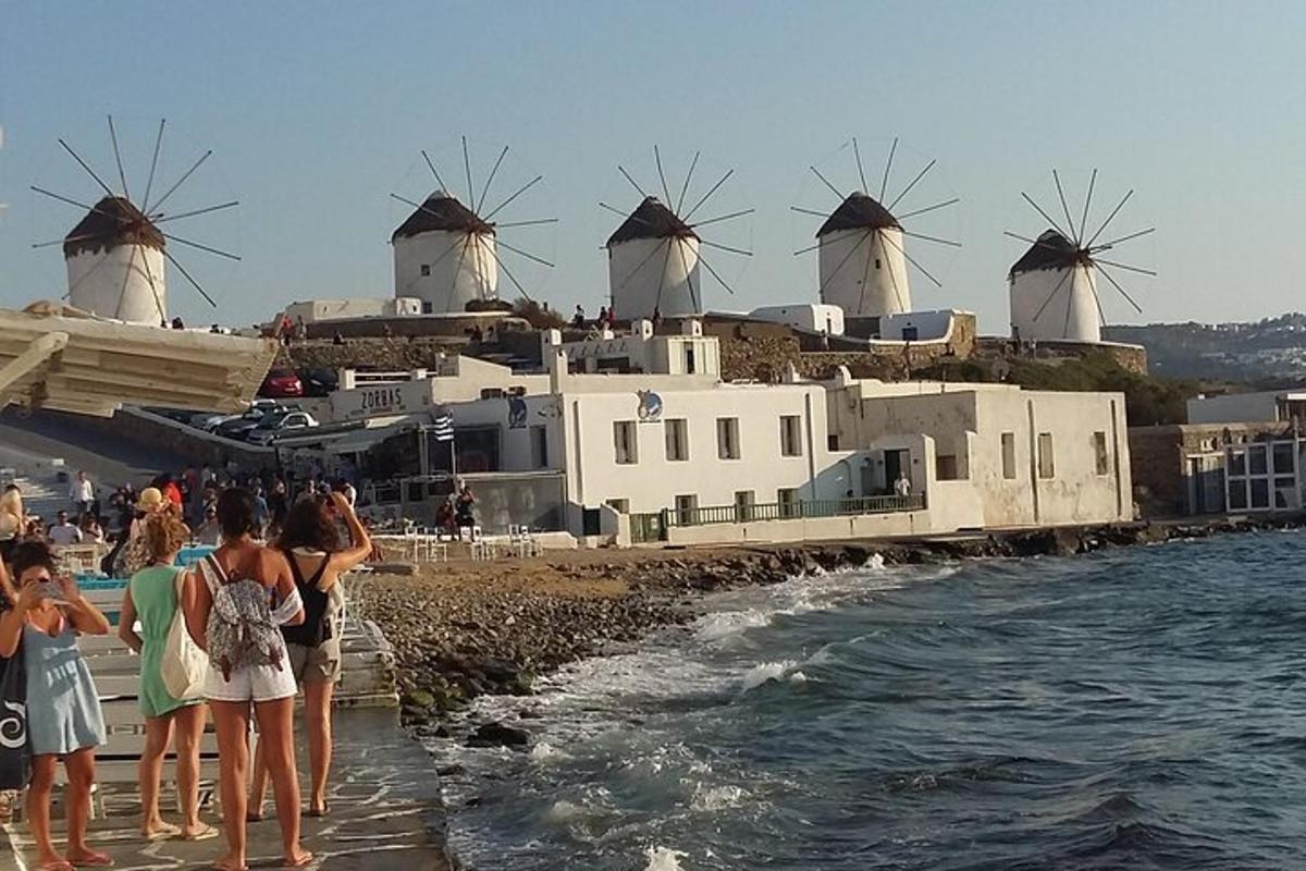 un grup de persones mirant un edifici amb molins de vent