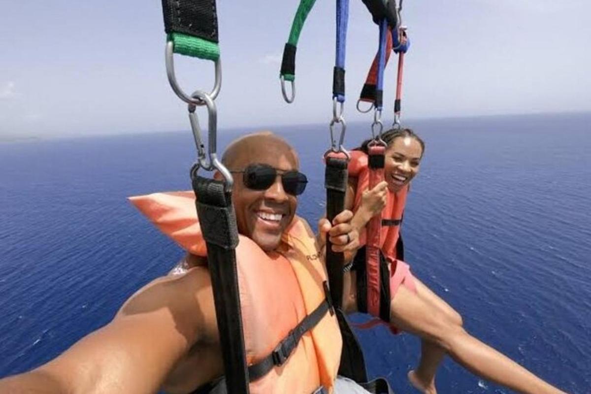 due persone in costume da bagno stanno volando su un paracadute