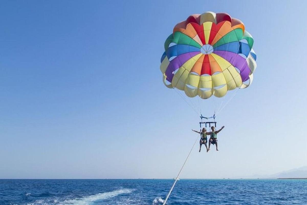 to personer i en fargerik fallskjerm over havet