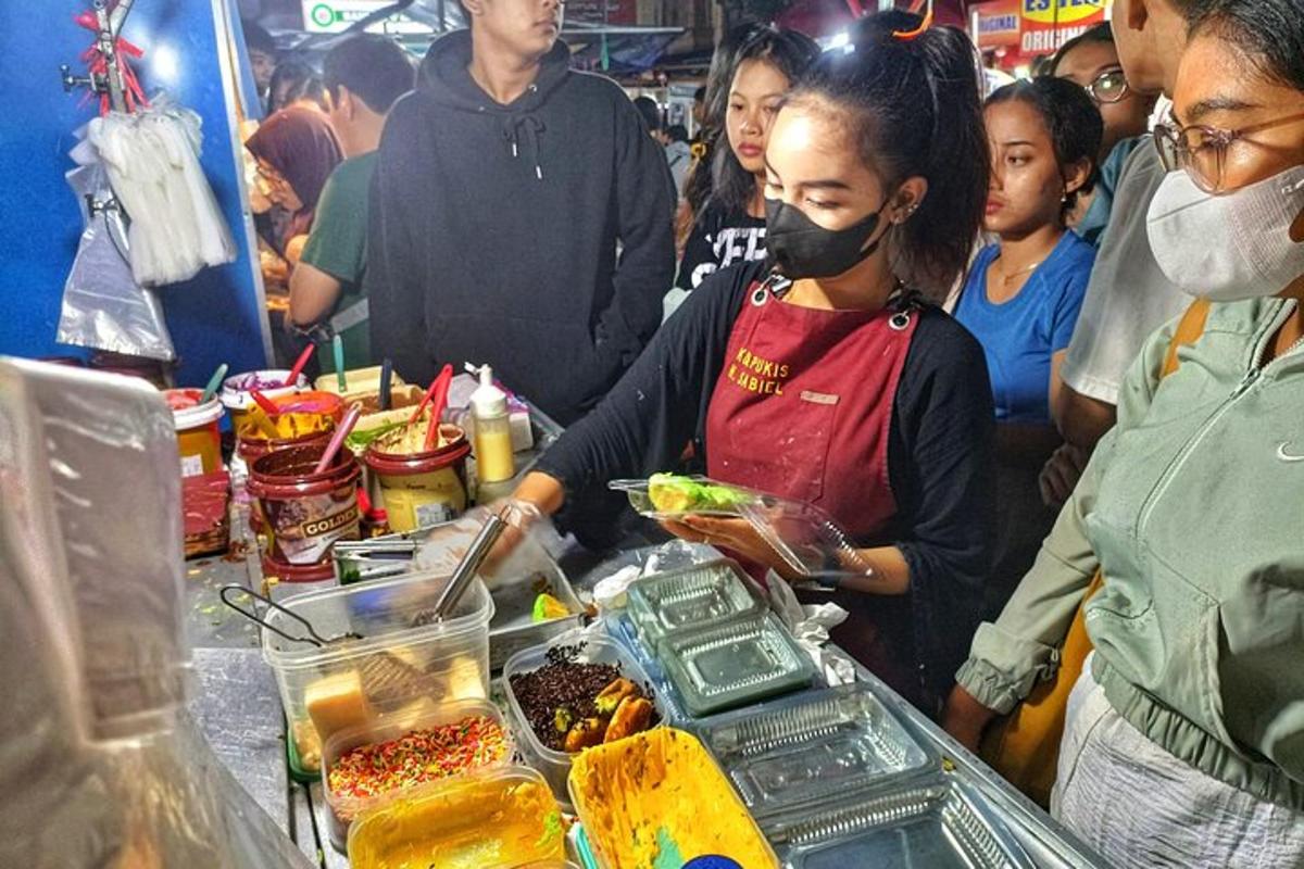 seorang wanita memakai topeng muka menyediakan makanan di bufet