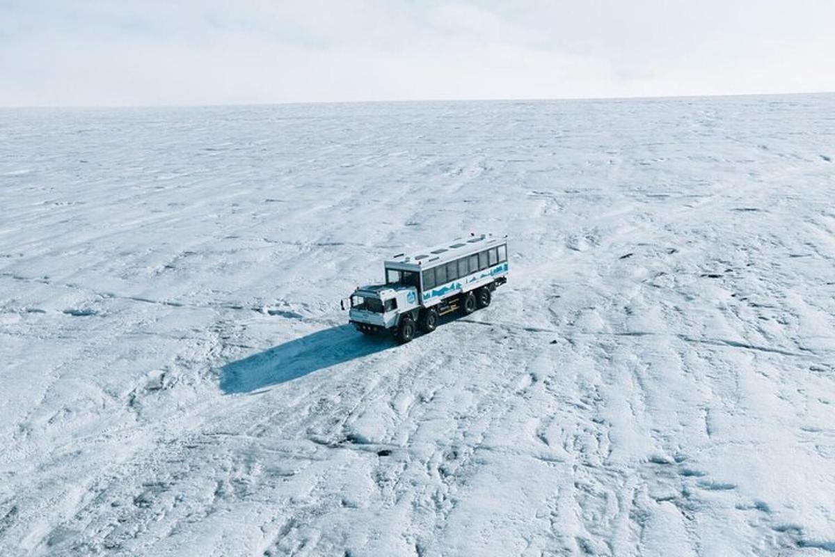 a truck driving across a snow covered field