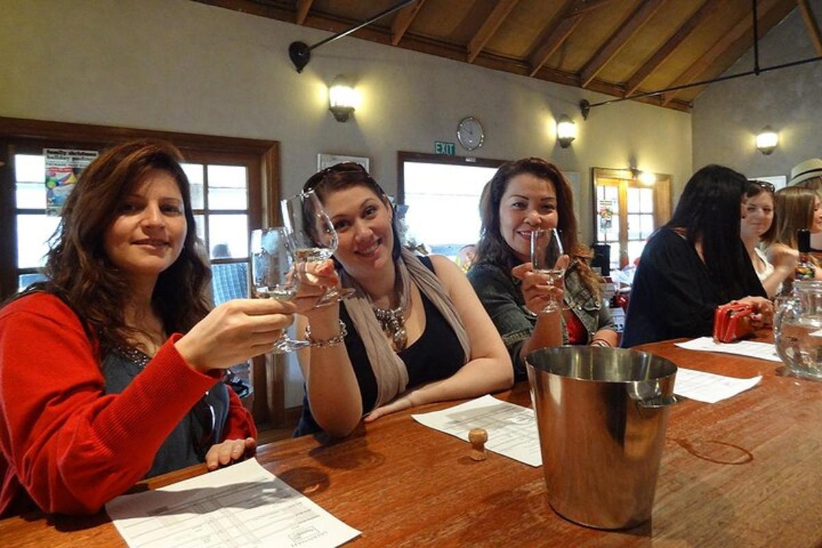 a group of women sitting at a table drinking wine