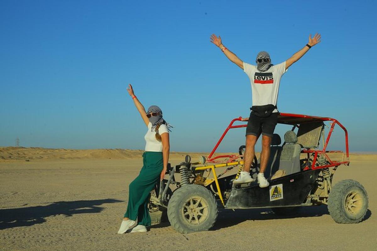 un uomo e una donna in piedi accanto a una jeep nel deserto