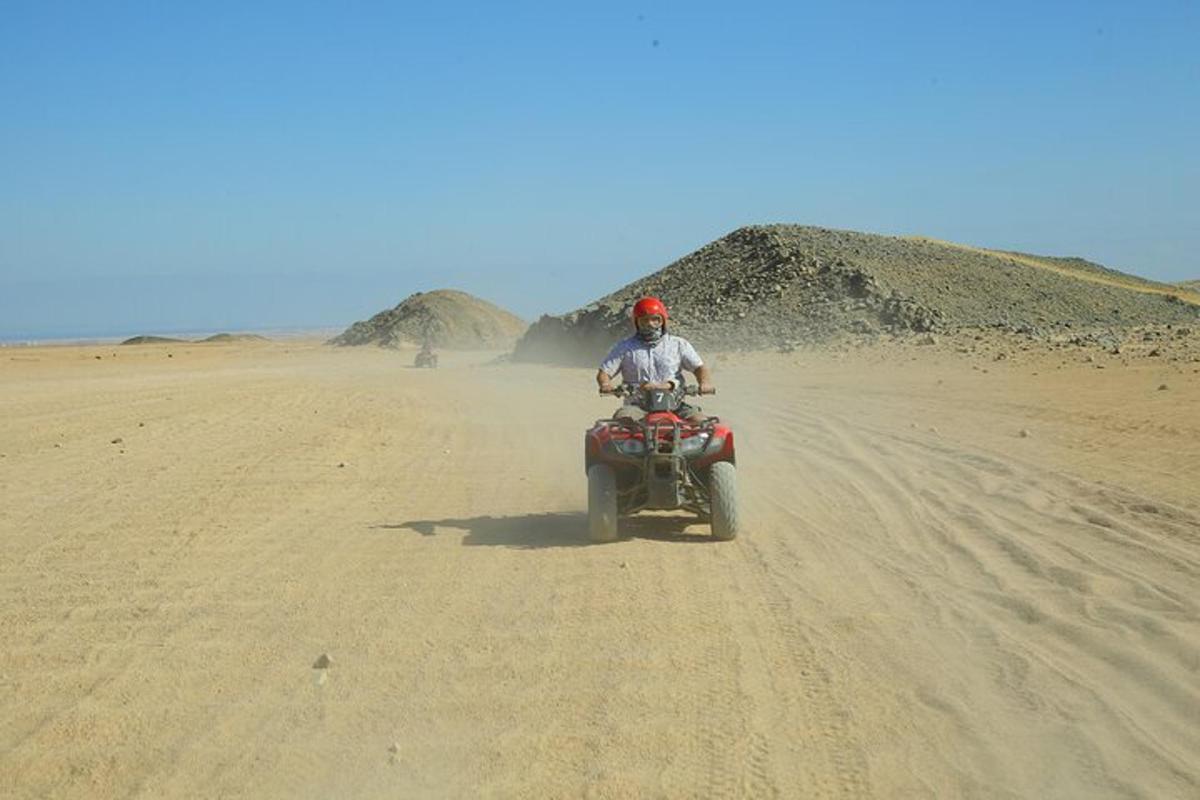 una persona che guida una moto da cross nel deserto