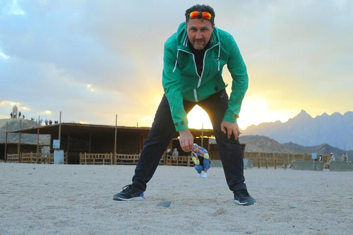 moški, ki stoji na plaži z žogo