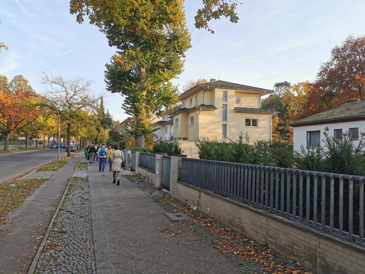grupp inimesi, kes kõnnivad mööda kõnniteed aia kõrval