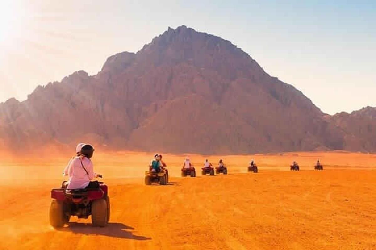 sekumpulan orang menunggang motosikal di padang pasir