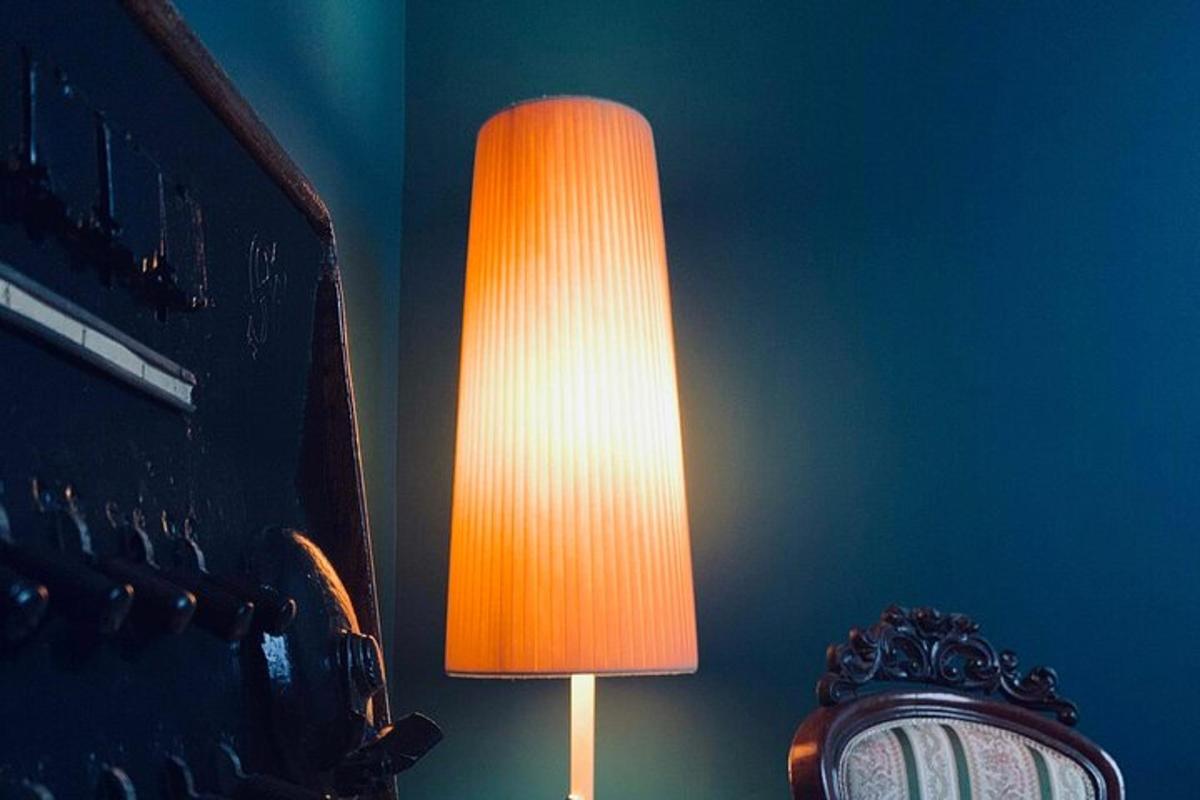 a lamp with an orange shade next to a clock