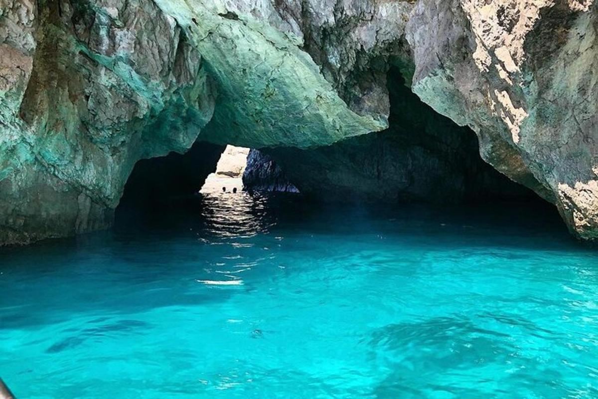 una grande grotta con acqua blu di fronte