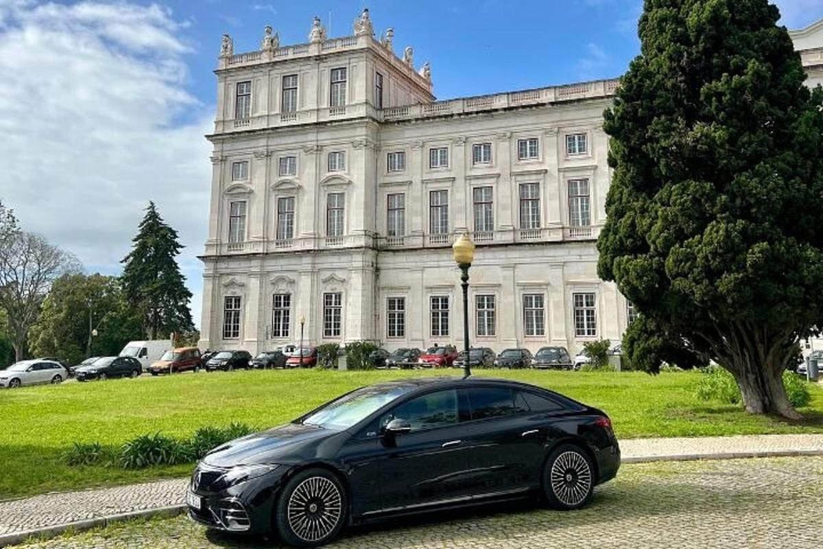 um carro preto estacionado em frente a um grande edifício