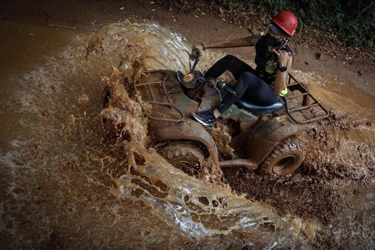 una persona che guida un quad nel fango