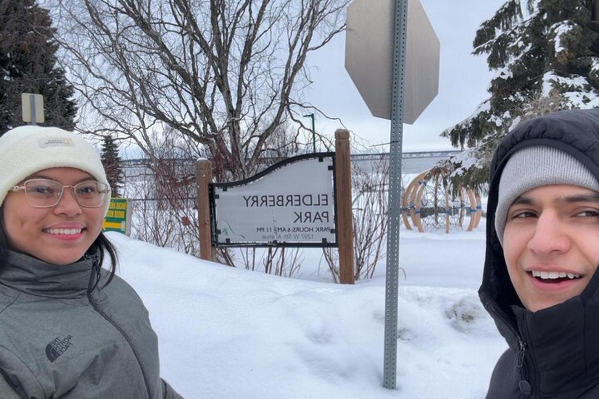 to personer som står ved siden av et stoppskilt i snøen
