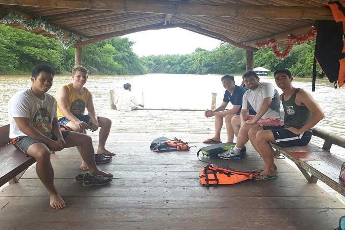 un gruppo di giovani uomini seduti su un molo