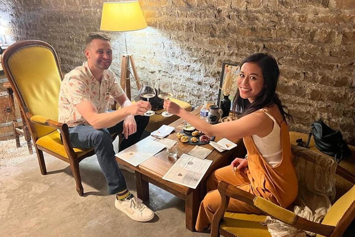 a man and woman sitting at a table with glasses of wine