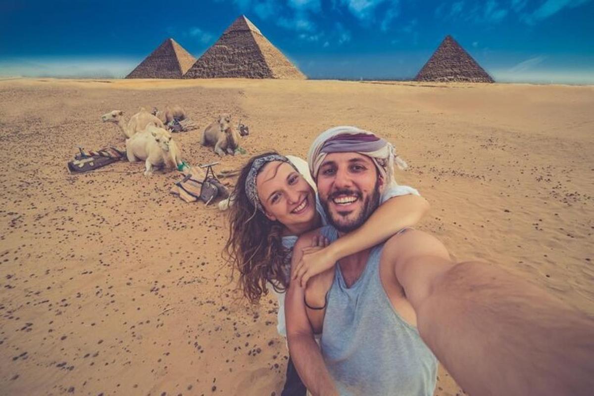en mann og en kvinne som poserer for et bilde foran pyramider