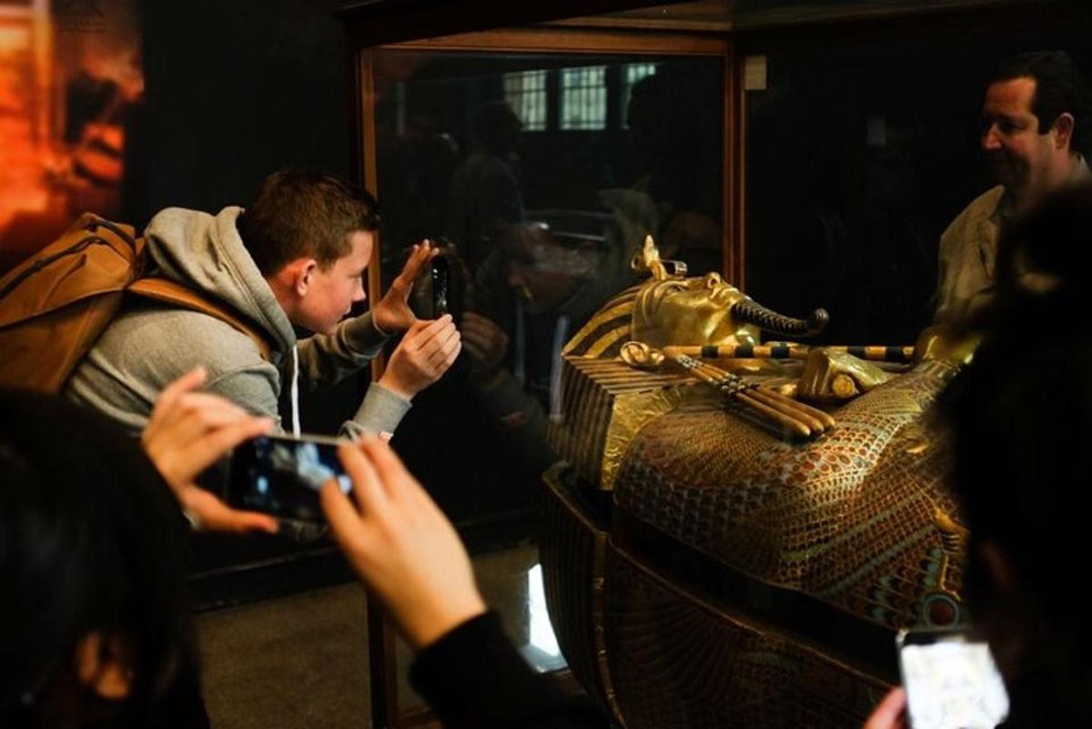 Un hombre tomando una foto de un bolso de oro.