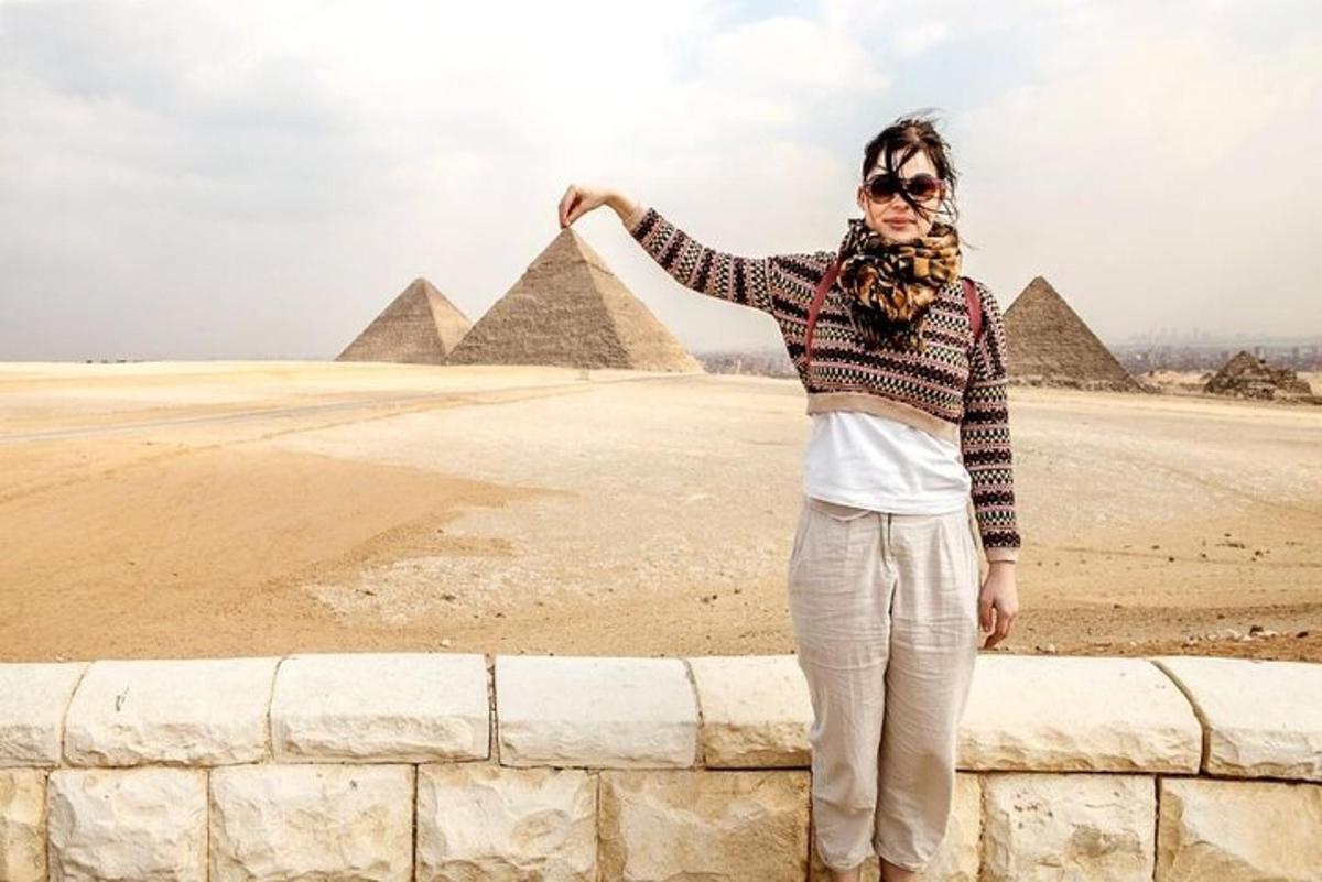 žena stojící na zdi před pyramidami