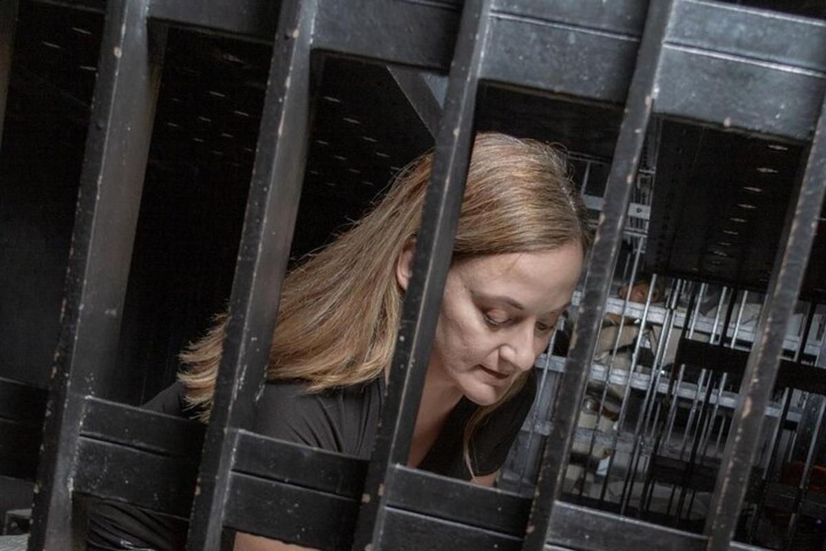 noor naine vaatab läbi metallvärava