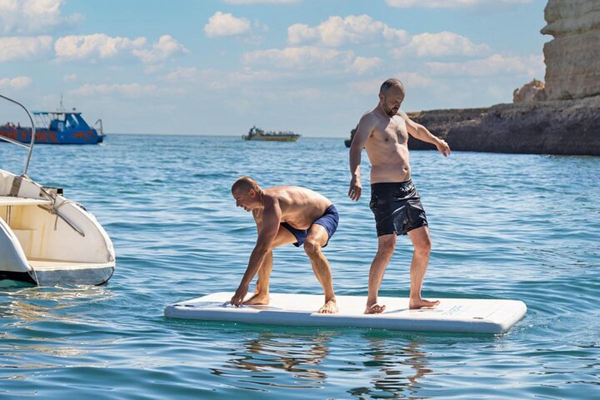 two men standing on a surfboard in the water