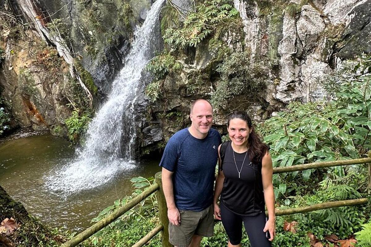un homme et une femme debout devant une cascade