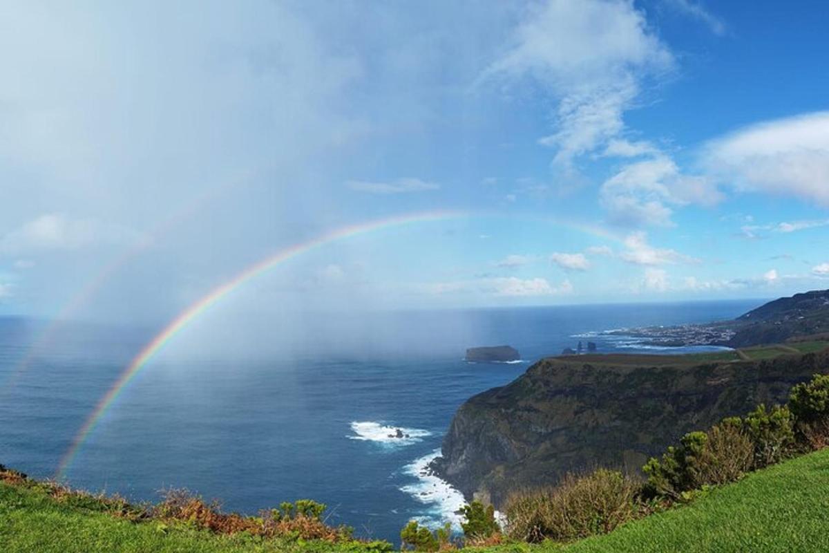 un arc-en-ciel sur l'océan avec une côte