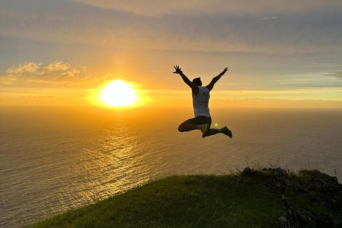 un homme sautant dans les airs avec le coucher de soleil en arrière-plan
