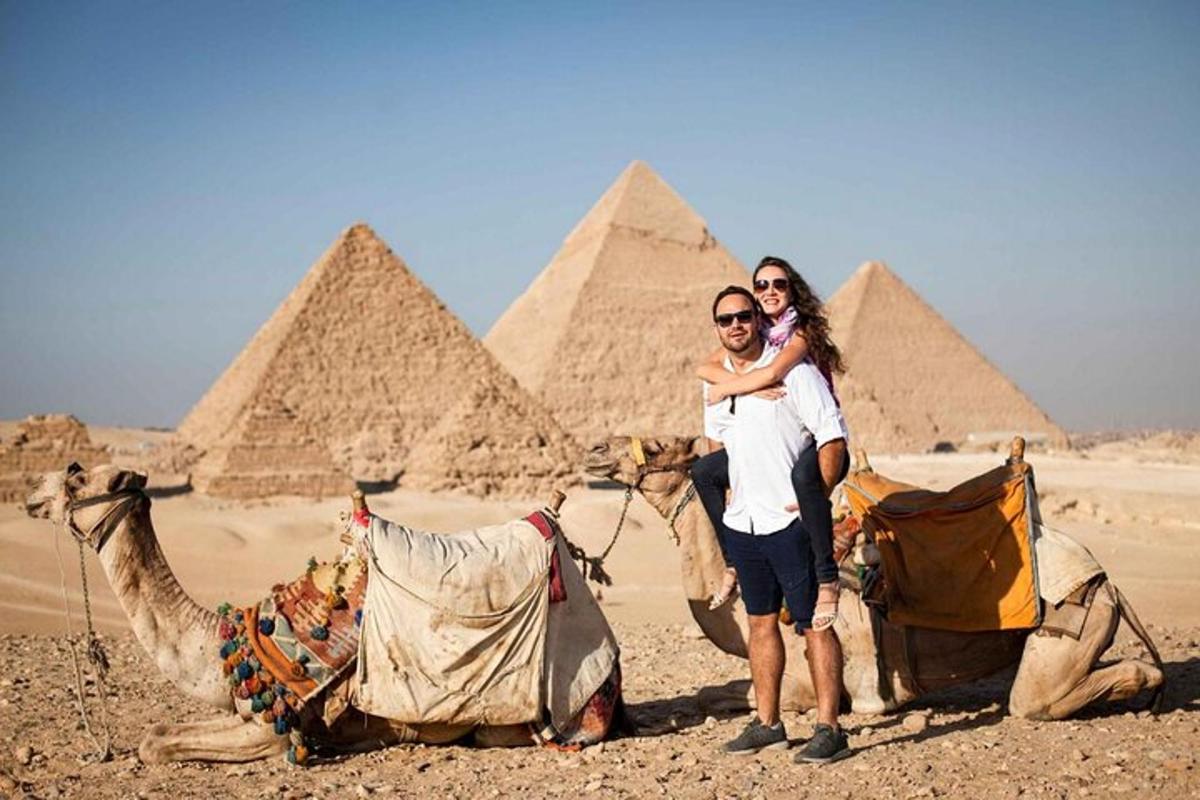 muž a žena pózující před pyramidami