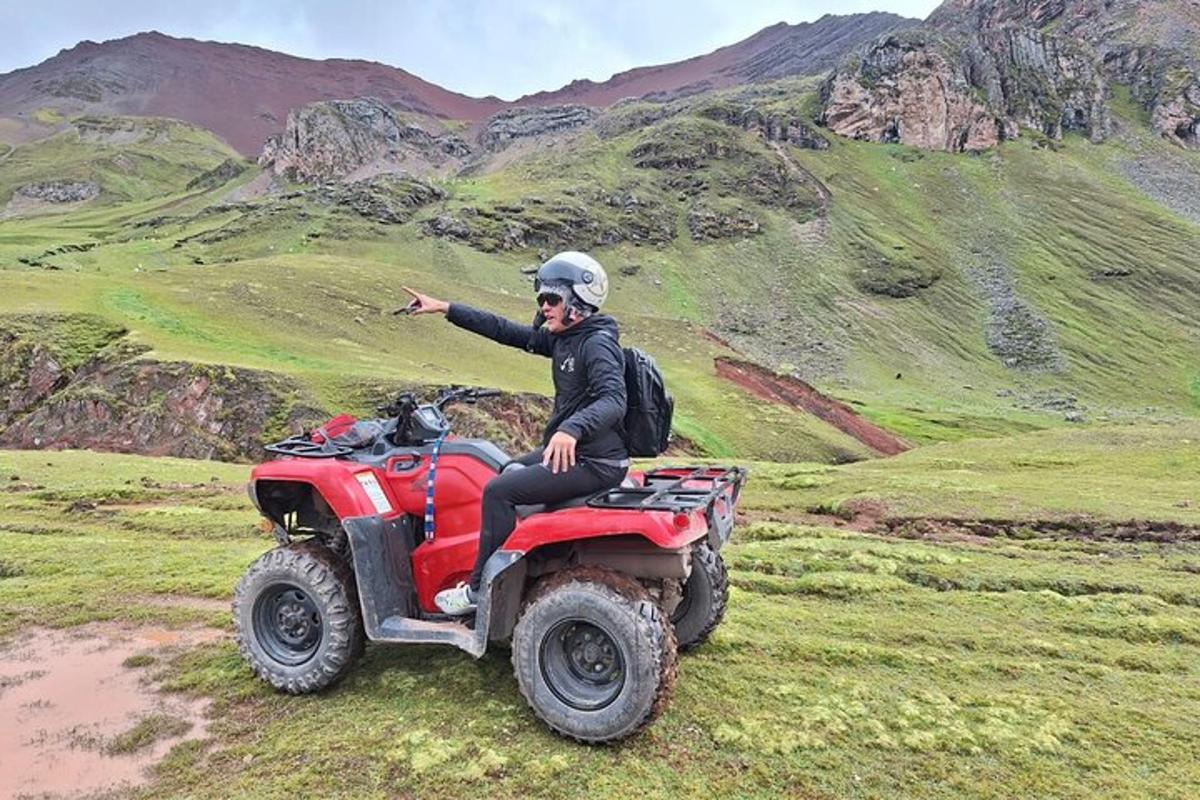 un home assegut en un quad a la muntanya