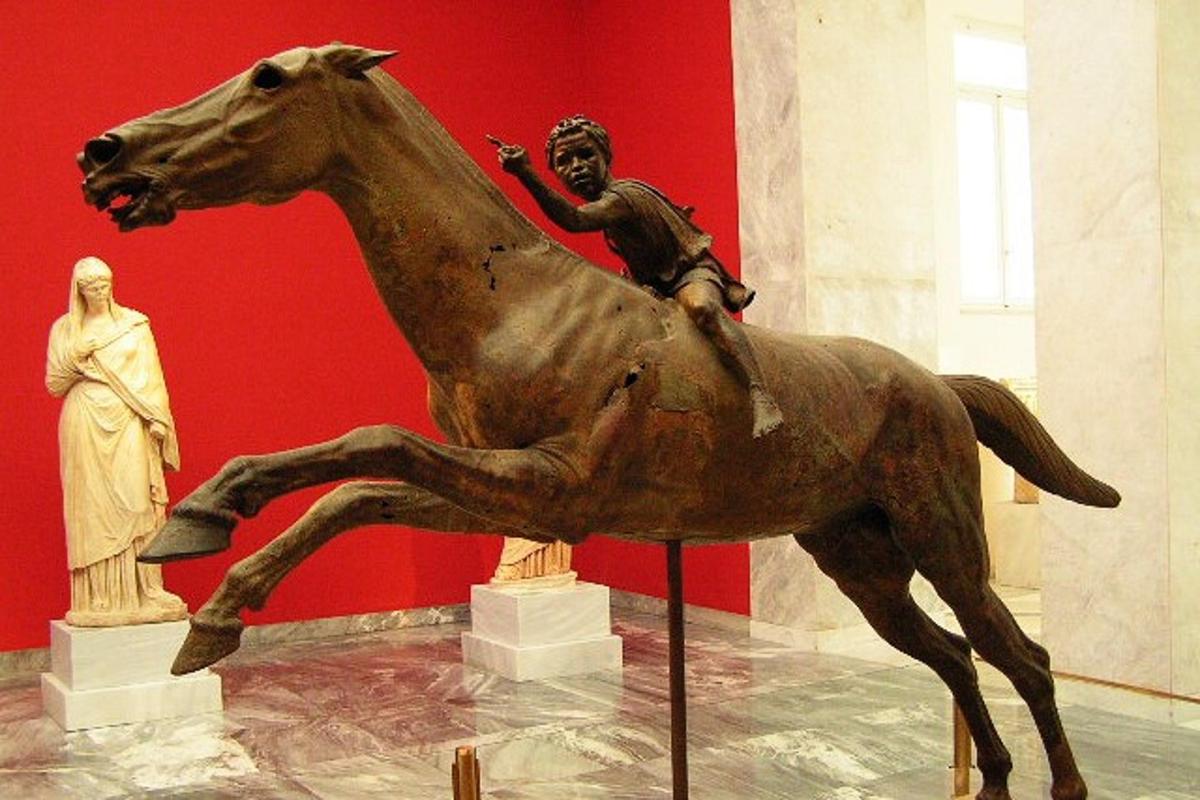 una estàtua d'un home muntant a cavall en un museu