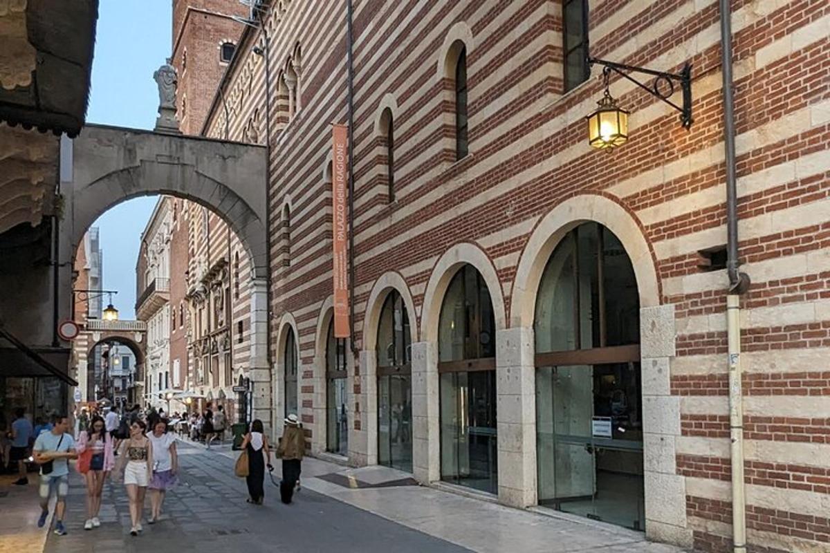 un gruppo di persone che camminano lungo una strada accanto a un edificio