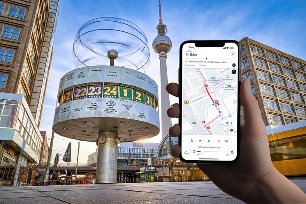 osoba držící mobilní telefon před věží