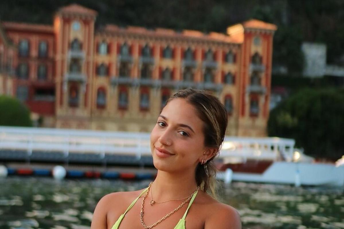 žena v zelených šatách stojaca pred budovou