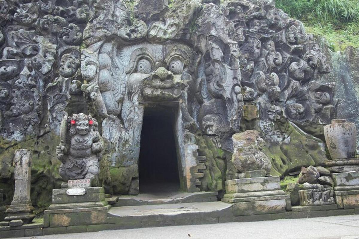Una entrada a una cueva de piedra con estatuas de personas.