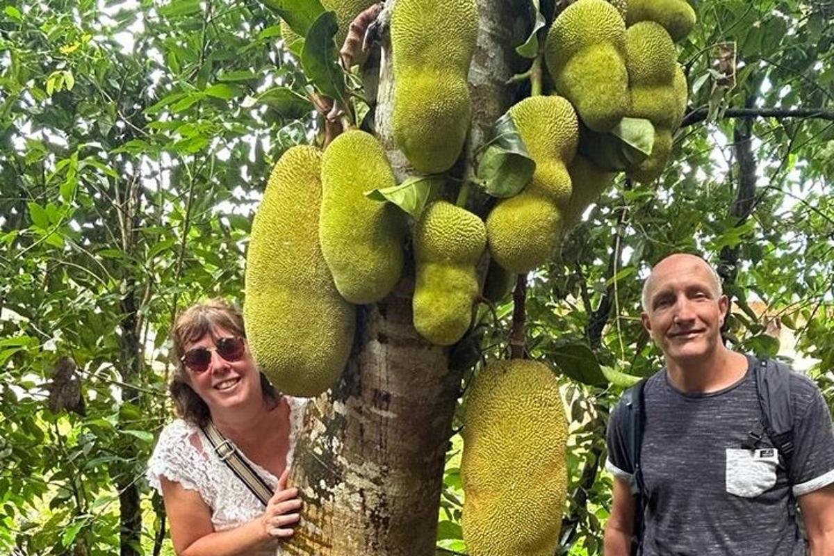 một người đàn ông và một người phụ nữ đứng cạnh một cái cây có trái