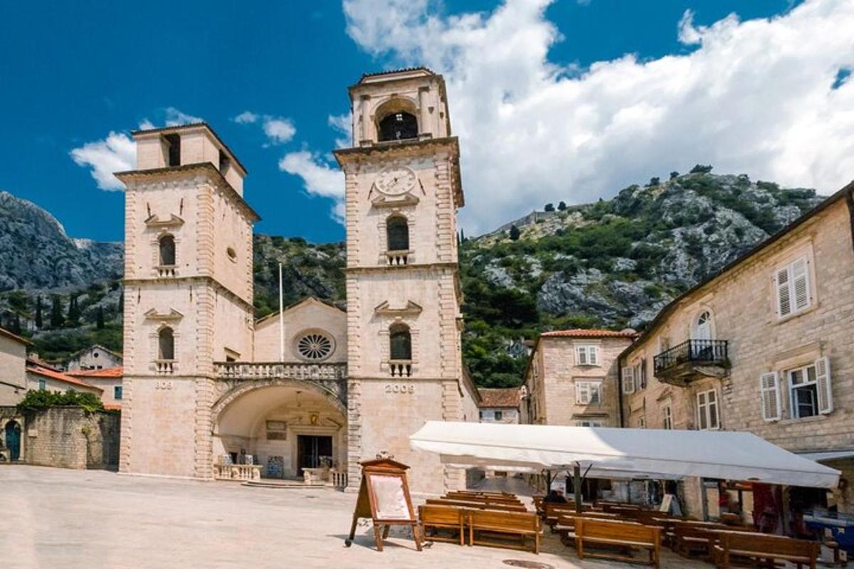 un edificio con una torre dell'orologio e delle panchine di fronte
