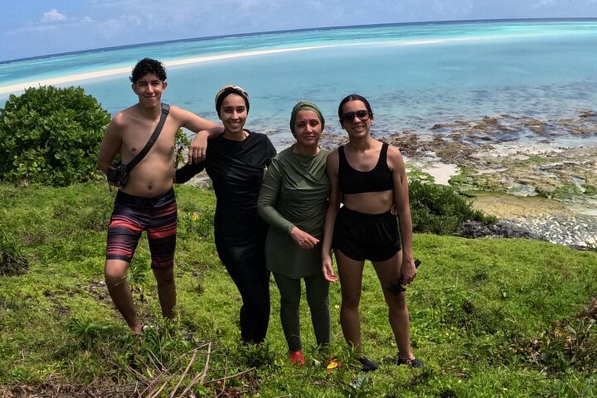 un gruppo di persone in piedi su una collina vicino all'oceano