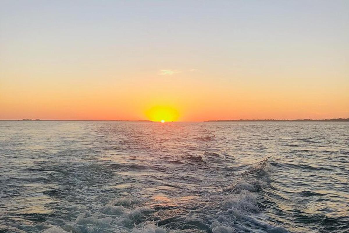 una posta de sol sobre una gran massa d'aigua
