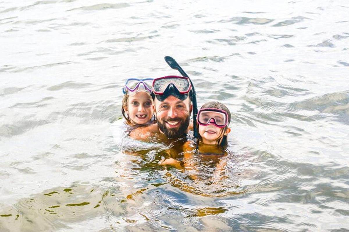 一名男子和两个孩子正在水中游泳