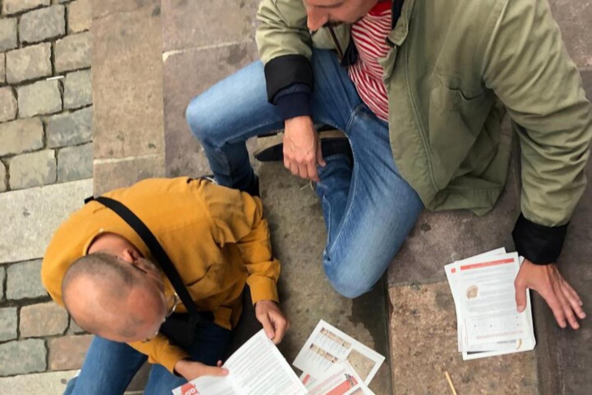 du vyrai sėdi ant žemės ir žiūri į kažką