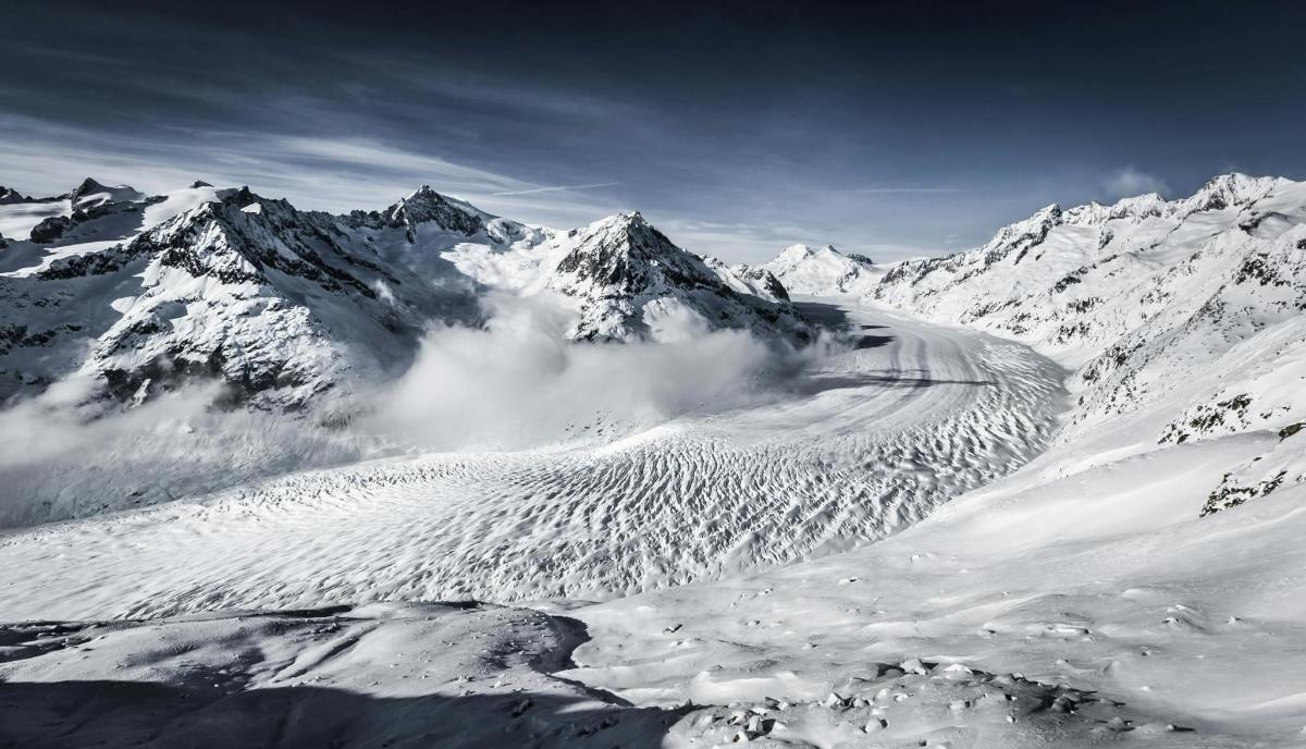 a snow covered mountain range with snow covered mountains
