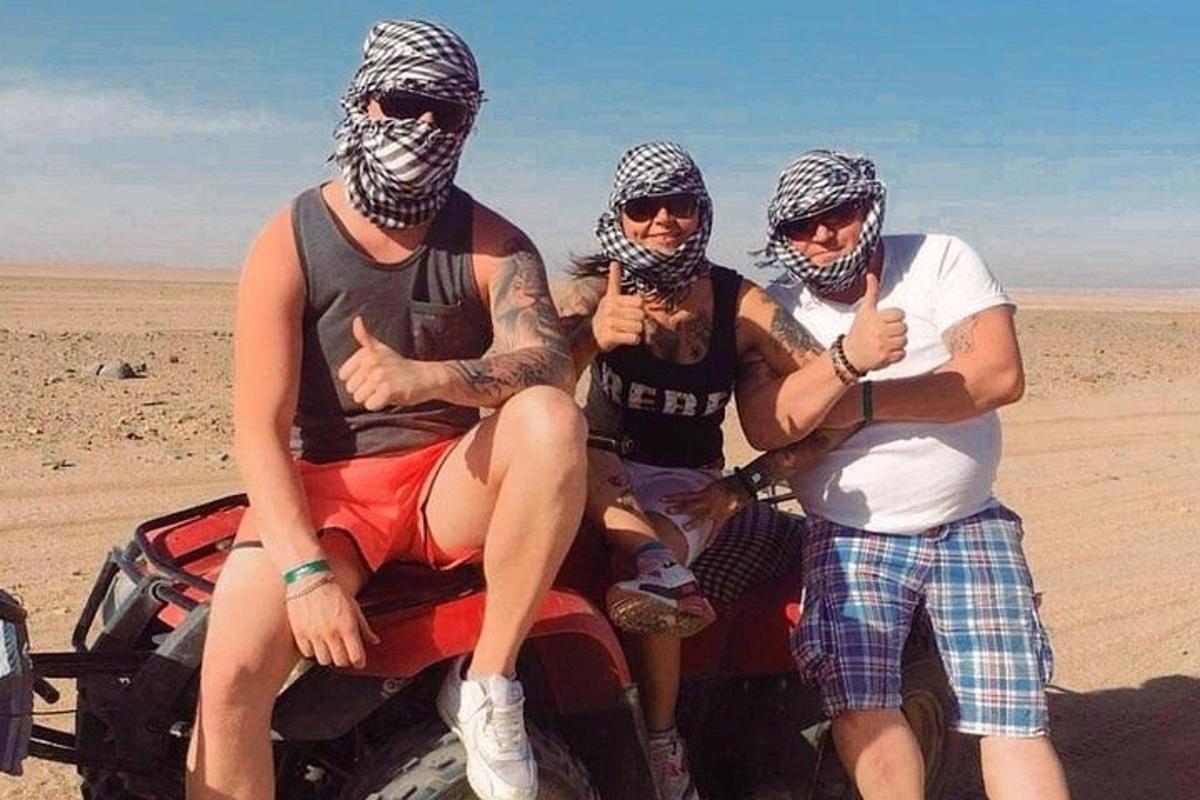 три человека сидят в кузове грузовика в пустыне