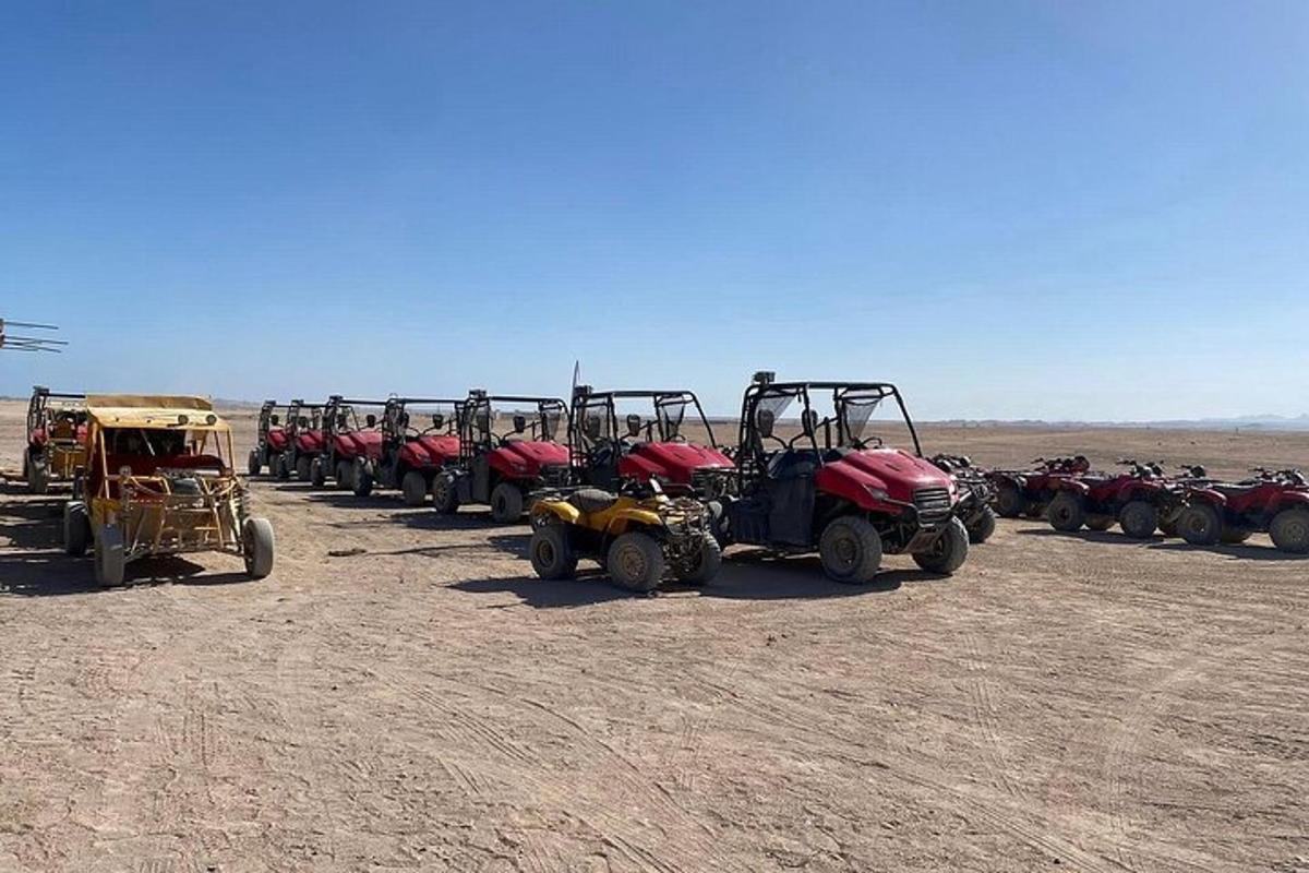 Una fila de vehículos todo terreno y vehículos estacionados en el desierto