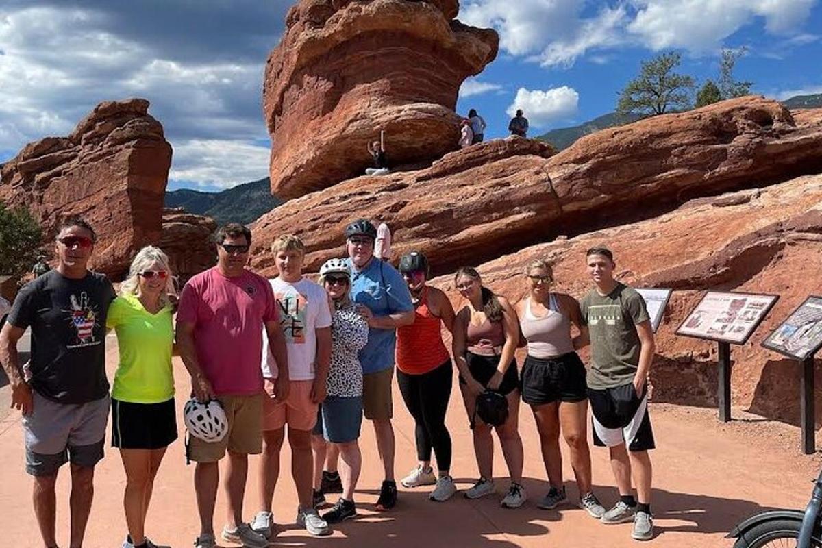 a group of people standing in front of a rock formation